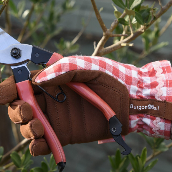 Rot karierte Gartenhandschuhe mit der roten Bypass-Gartenschere